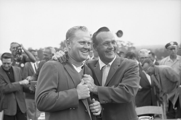 (Original Caption) Augusta, Georgia: Arnold Palmer, defending champion, (right), helps adjust traditional green coat, symbol of Masters champs, on ...
